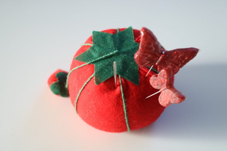 tomato pin cushion with butterfly pins
